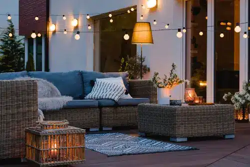 Cozy outdoor living space with couch, lighting, and covered patio