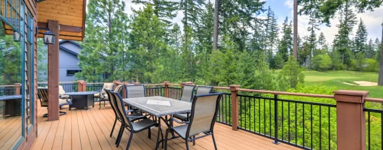 Large wood deck with railing overlooking a wooded backyard, illustrating a traditional deck option for Brookings coastal properties.